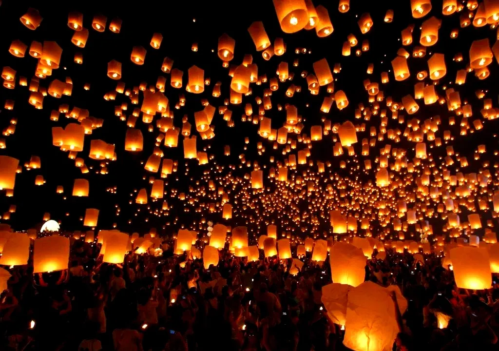 People releasing flying lanterns into the night sky